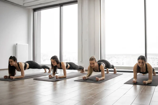 在健身中心进行瑜伽训练时 年轻的女运动员用前臂板垫加强了整个身体 采用Phalakasana Ii运动改善运动服装姿势的体态的肥胖妇女 — 图库照片