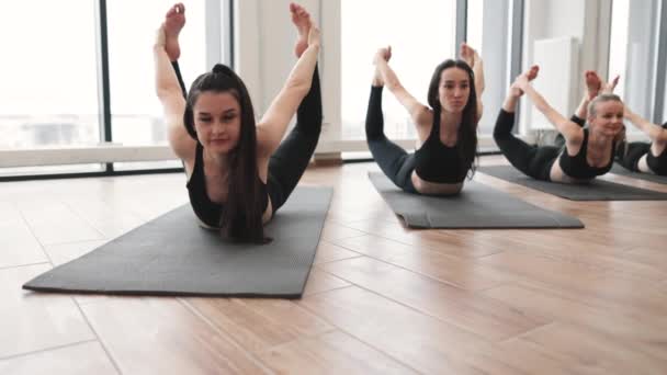 与健身中心的其他女性同行一起 在运动服练习达努拉萨纳运动时 专注于吸引人的黑发瑜伽尼 身强体壮的女士在室内做俯卧撑时 能锻炼颈部肌肉 — 图库视频影像