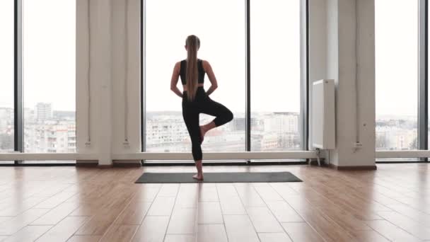 Vista Posterior Esbelta Mujer Rubia Top Negro Pantalones Yoga Sosteniendo — Vídeos de Stock