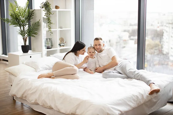 Genç Ebeveynler Arka Planda Panoramik Pencereleri Olan Rahat Bir Yatakta — Stok fotoğraf