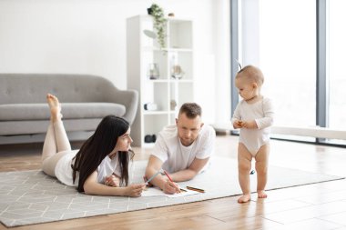 Neşeli ebeveynler rengarenk kalemlerle çizim yaparken, sevimli bebekler güneşli hafta sonlarında ferah odalarda dolaşıyorlar. Genç yetişkinler küçük kızı evde yaratıcılığa teşvik ediyor..