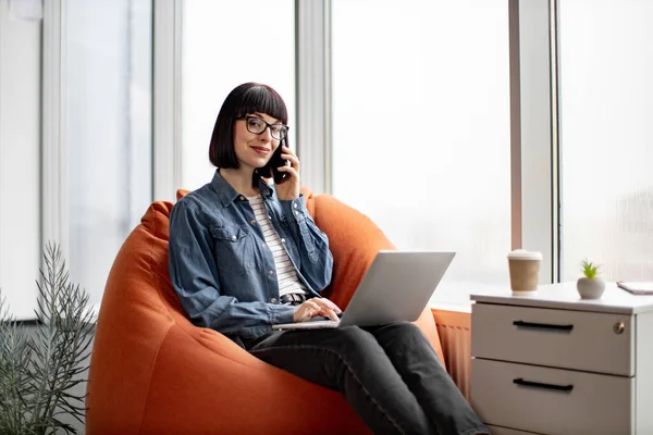 Ofiste Dizüstü Bilgisayarla Çalışırken Gözlüklü Günlük Giyinmiş Beyaz Bir Bayan — Stok fotoğraf