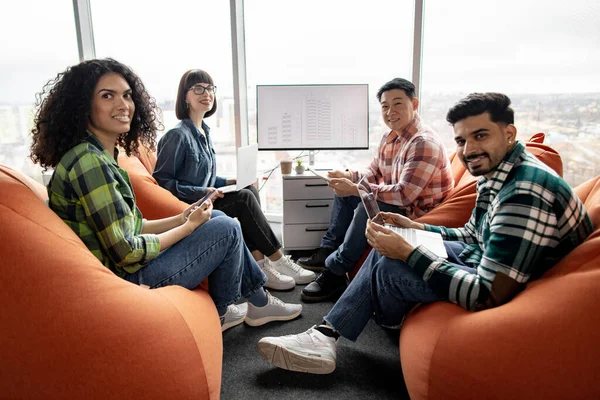 Négy Mosolygós Üzlettárs Pózol Kézi Eszközökkel Coworking Térben Interaktív Kijelzővel — Stock Fotó
