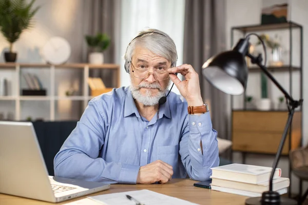 Vidám Idősebb Felnőtt Fülhallgatóban Aki Olvasószemüvegen Leskelődik Miközben Hosszú Órákon — Stock Fotó