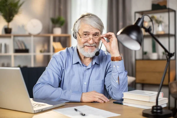 Vidám Idősebb Felnőtt Fülhallgatóban Aki Olvasószemüvegen Leskelődik Miközben Hosszú Órákon — Stock Fotó