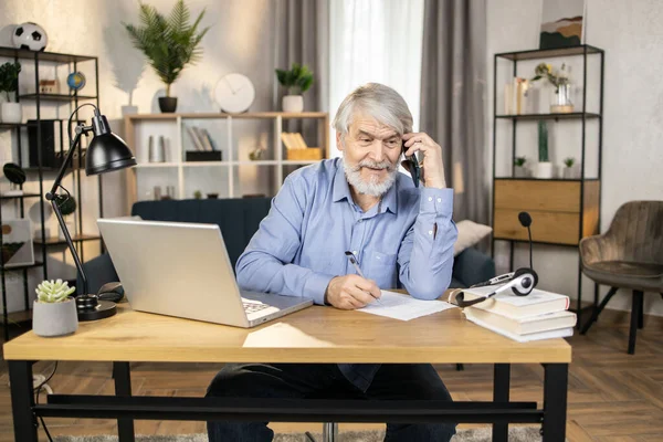 Idős Férfi Kék Galléros Ingben Mobilon Beszél Miközben Irodai Asztalnál — Stock Fotó