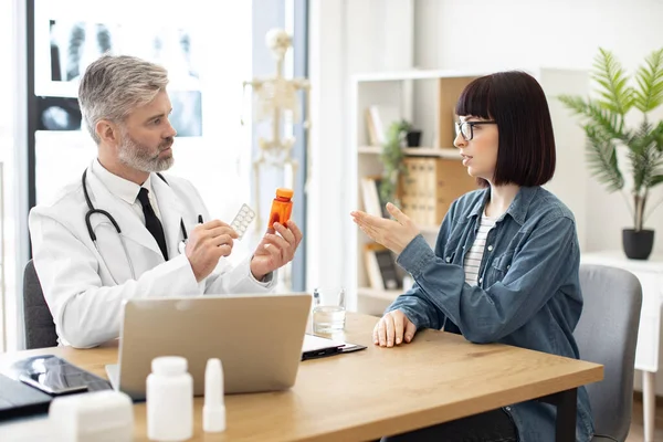 Felnőtt Férfi Fehér Kabátban Gyógyszerekkel Kezében Miközben Egy Gyönyörű Nővel — Stock Fotó