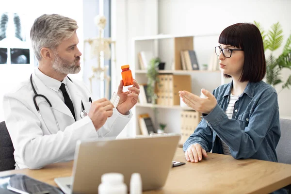 Felnőtt Férfi Fehér Kabátban Gyógyszerekkel Kezében Miközben Egy Gyönyörű Nővel — Stock Fotó