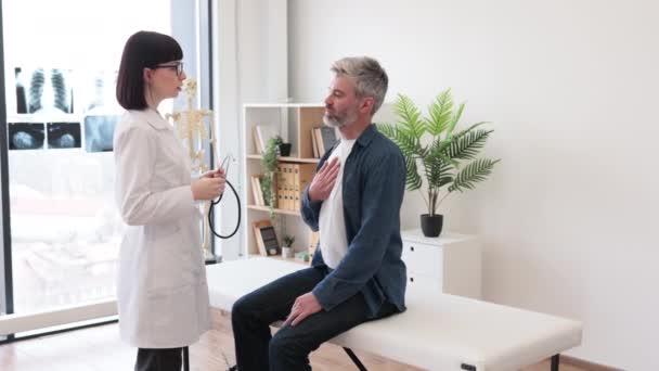 Endişeli Gri Saçlı Adam Doktor Önlüklü Kadın Stetoskop Tutarken Elleri — Stok video