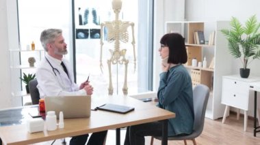 Laboratuvar önlüklü profesyonel bir adam ve doktor ofisinde yazı masasında oturan boyunluk takan çekici bir kadın. Boyun yaralanması nedeniyle ayakta tedavi gören beyaz bir bayan..