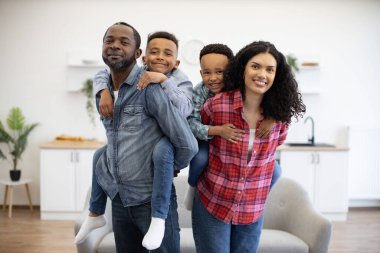 Güneşli bir günde işten uzak bir şekilde birlikte eğlenirken meraklı oğullar taşıyan sağlıklı, çok kültürlü ebeveynler. Dört kişilik tasasız bir aile, koşulsuz sevgi ve birbirlerine destek gösteriyorlar..