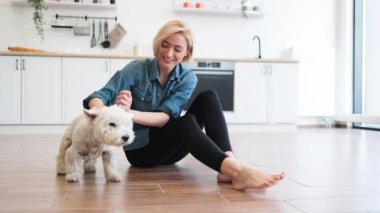 Her gün sakin bir kadın, iş günü evde dinlenirken beyaz, orta boy teriyer giyer. Baya kısa saçlı bir sarışın kendini evinde güvende hissederken sevimli Batısını sevgiyle okşuyor..