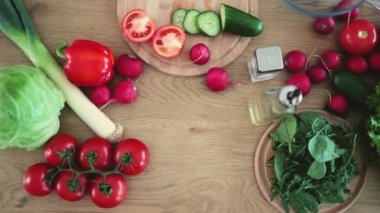 Domates, lahana, pırasa, dolma biber, turp, salatalık ve ahşap yüzeyde yapraklı yeşillik karışımı. Besleyici yemekler için sağlık faydalarıyla yüklü klasik çıtır ürünler..