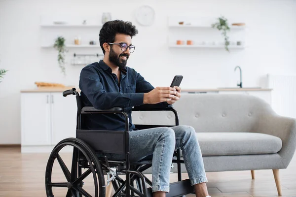 Lächelnder Arabischer Erwachsener Rollstuhl Der Auf Den Handybildschirm Schaut Während — Stockfoto