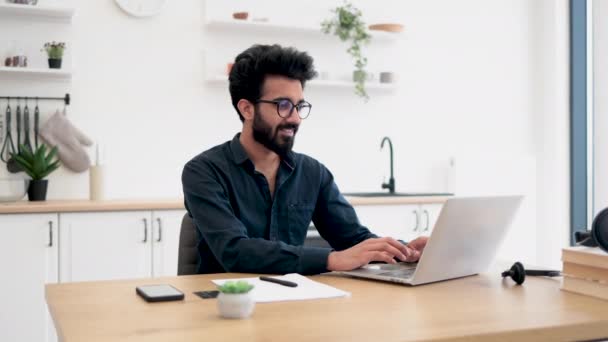 Homem Barbudo Alegre Óculos Operando Laptop Moderno Enquanto Sentado Escrivaninha — Vídeo de Stock