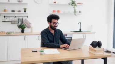 Mikrofonlu, belgeli ve taşınabilir bilgisayarlı gülümseyen insan portresi. Neşeli Arap danışmanı müşterilerine dijital platformdan rehberlik sunuyor..