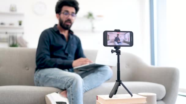 Kanepede Dizüstü Bilgisayarla Oturan Akıllı Telefon Kamerasıyla Konuşan Neşeli Bir — Stok video