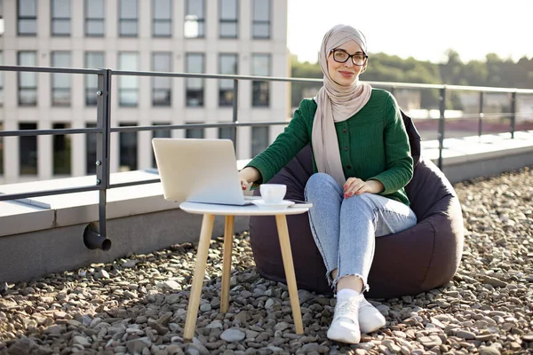 Vonzó Muszlim Fejkendőben Modern Laptopot Futtat Dohányzóasztalon Miközben Szabadban Egy — Stock Fotó