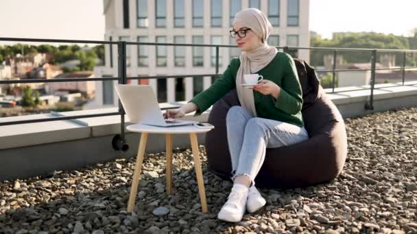 Porträtt Ung Kvinna Hijab Dricka Kaffe Medan Placerar Laptop Ett — Stockvideo