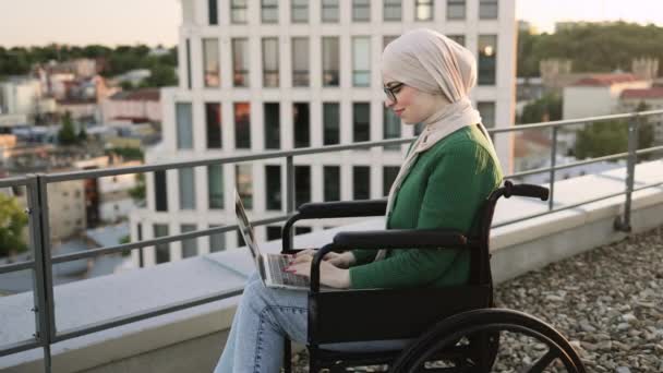 Mulher Muçulmana Confiante Lenço Cabeça Óculos Digitando Laptop Enquanto Segurava — Vídeo de Stock