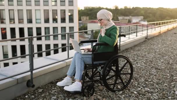 Cheerful Muslim Female Headscarf Looking Laptop Webcam While Sitting Wheelchair — Stock Video