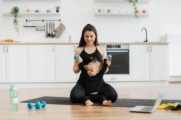 Young happy mother working out, doing butt bridge exercise