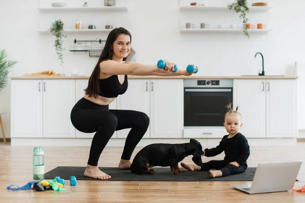 Sorrindo Morena Senhora Exercitando Com Halteres Enquanto Relaxado Alimentação Infantil — Fotografia de Stock