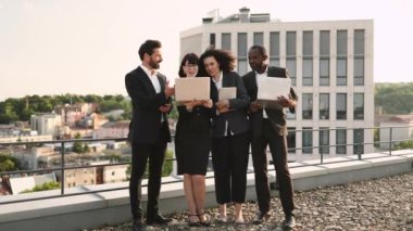 Kafkas ve Afrika kökenli Amerikalı mutlu girişimcilerin portresi yan yana duruyor ve kameraya gülümsüyor. Modern aletleri elinde tutan çekici iş ortakları..