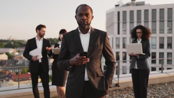 Портрет Успешного Африканского Предпринимателя Держащего Руках Мобильный Телефон Улыбающегося Камеру — стоковое видео