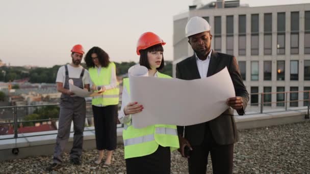 레이아웃을 부동산 프로젝트에 토론하는 전문가 백인짧은 아프리카 미국인 건설의 외관을 — 비디오