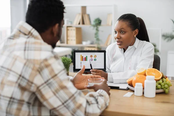 아프리카 미국인 실에서 환자의 정보를 디지털 태블릿으로 분석하는 센터에서 고객의 — 스톡 사진