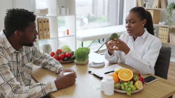 Dietista Afro Americano Jaleco Branco Colocando Abacate Fresco Escala Nutricional — Vídeo de Stock