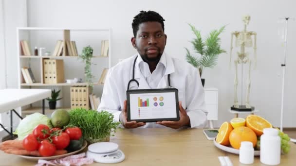 Självsäker Afrikansk Amerikansk Man Läkare Päls Visar Tablett Med Diet — Stockvideo