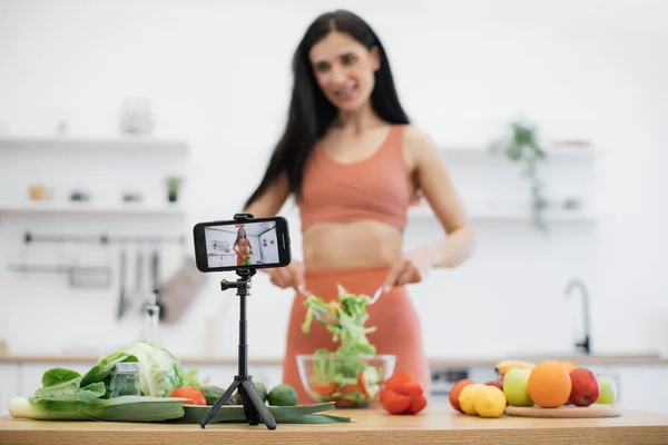 Mutfak Masasının Üzerine Yerleştirilmiş Dijital Telefon Sebze Salatası Hazırlayan Gülümseyen — Stok fotoğraf