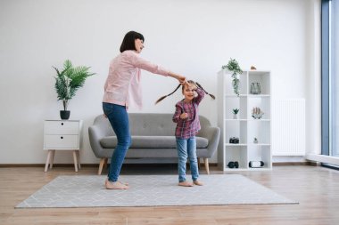 Aktif bir ebeveyn ve genç bir çocuk modern bir dairede sıcak zeminde dönerken neşeli melodiler dinliyorlar. Gerçek müzik severler ev içinde popüler rock 'n roll müziğiyle kıvranıyor..