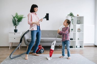 Elektrikli süpürgeyi hayali gitar olarak kullanan heyecanlı bir anne ve kablosuz cihazla rock şarkıcısı rolü yapan bir kız. Ev hanımları hafta sonları evde bakım görevlerini paylaşırken eğleniyorlar..