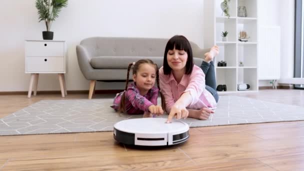 Ευτυχισμένη Μητέρα Και Κόρη Πιέζουν Κουμπί Στο Λευκό Ρομποτικό Κενό — Αρχείο Βίντεο