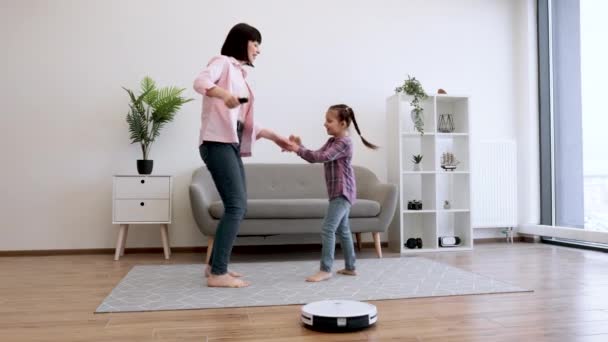 Young Lady Showing Dance Moves Little Girl While Robotic Vacuum — Stock Video