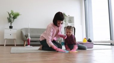 Salonda halısız temizleme spreyi ile çekici bir kadın, lateks eldivenli tatlı bir kız da yardım ediyor. Ev bakımıyla ilgilenen rahat kıyafetler içindeki enerjik aile ikilisi..