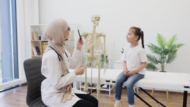 Πορτραίτο Γυναίκας Μαντίλα Που Δείχνει Ιατρικό Μοντέλο Σκελετού Ενώ Καυκάσιος — Αρχείο Βίντεο