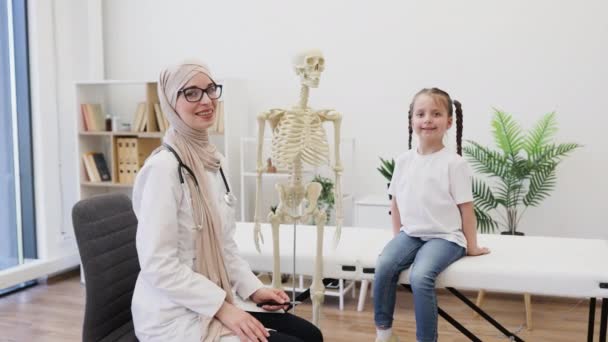 Hidzsábi Portréja Amint Orvosi Csontvázmodellt Mutat Míg Alkalmi Ruhás Kaukázusi — Stock videók