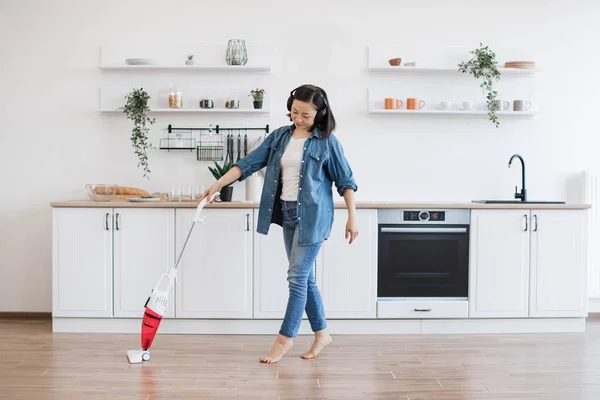 Vivid Barefoot Woman Cleaning Floor Kitchen Upright Vacuum While Listening — Stock Photo, Image