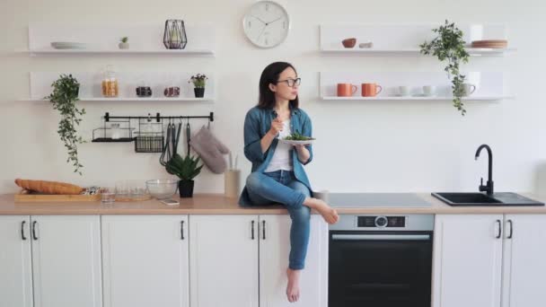 Çekici Bir Kadının Şık Bir Mutfakta Vejetaryen Yemeğiyle Tezgahta Dinlendiği — Stok video
