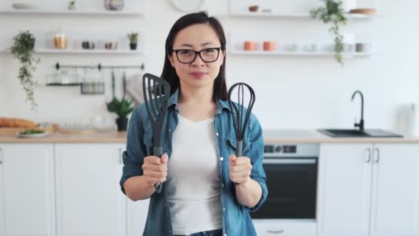 Πορτρέτο Του Χαμογελαστού Κινεζική Γυναίκα Δείχνει Εξοπλισμό Μαγειρικής Ενώ Στέκεται — Αρχείο Βίντεο