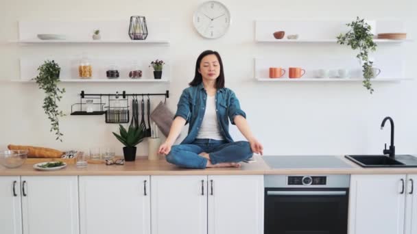 Vrolijke Aziatische Vrouw Casual Kleding Glazen Ontspannen Lotus Poseren Aanrecht — Stockvideo