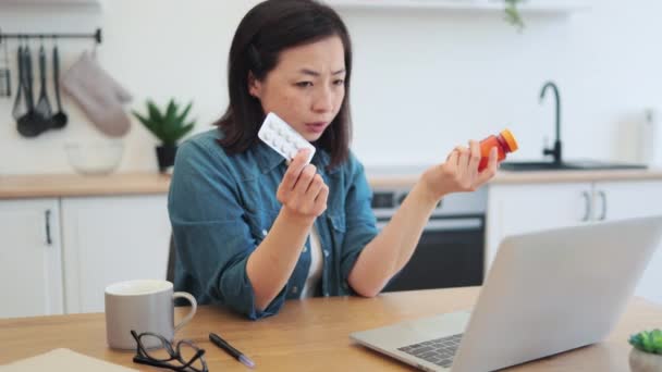 ラップトップを介して一般開業医からオンライン相談を受ける手の医学を持つ若いアジアの女性 不健康なフリーランサーは アレルギーシーズン中に鼻臭い治療に関するアドバイスを求める — ストック動画