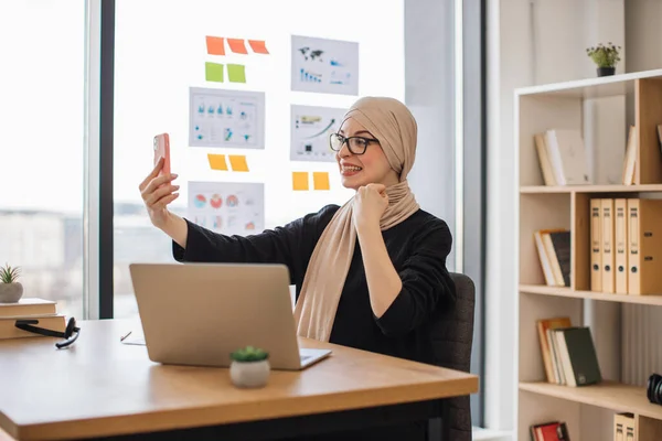 Mulher Bonita Hijab Segurando Telefone Celular Nível Dos Olhos Enquanto — Fotografia de Stock