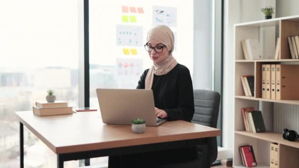 漂亮的阿拉伯女人穿着头巾在工作场所用手提电脑主持互动小组会议 高效率的首席执行官与区域办事处营销小组讨论问题 — 图库视频影像