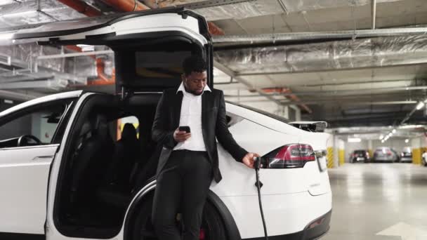 Selbstbewusster Geschäftsmann Steckt Passenden Stecker Batteriebetriebenes Fahrzeug Auf Öffentlichem Parkplatz — Stockvideo