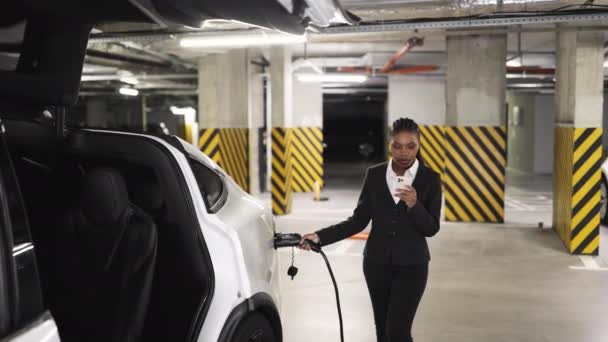 Afroamerikanerin Offizieller Kleidung Scannt Handy Bildschirm Während Sie Stromkabel Auto — Stockvideo